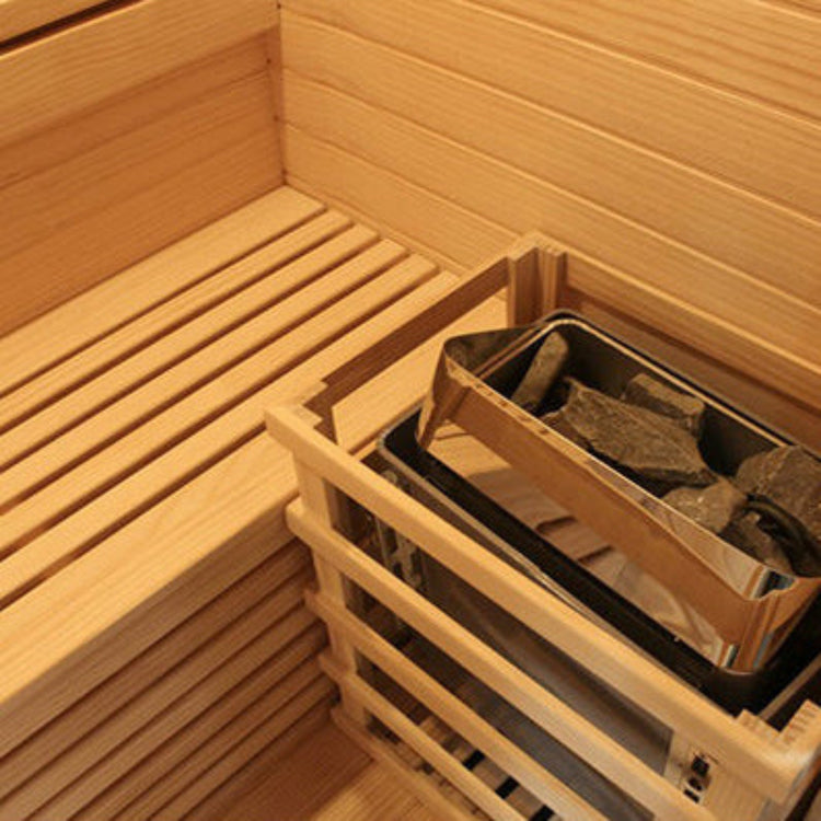 Wooden sauna interior with a heater containing stones.